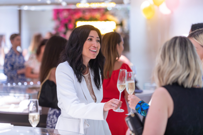 Eine Frau hält auf einer Party ein Glas Wein.