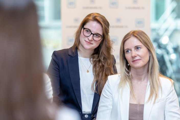 Zwei Frauen sitzen an einem Tisch und reden miteinander.