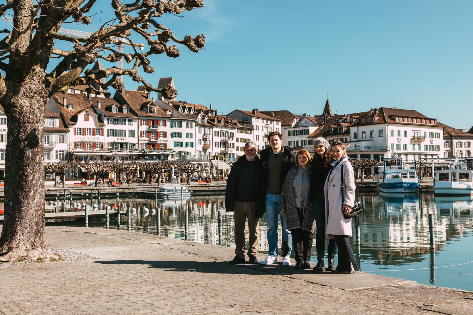 A photographer captures a group of people posing in front of a lake in Rapperswil Jona, Switzerland.