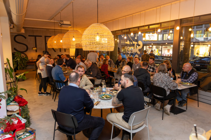 Eine Gruppe von Menschen sitzt an Tischen in einem Restaurant.