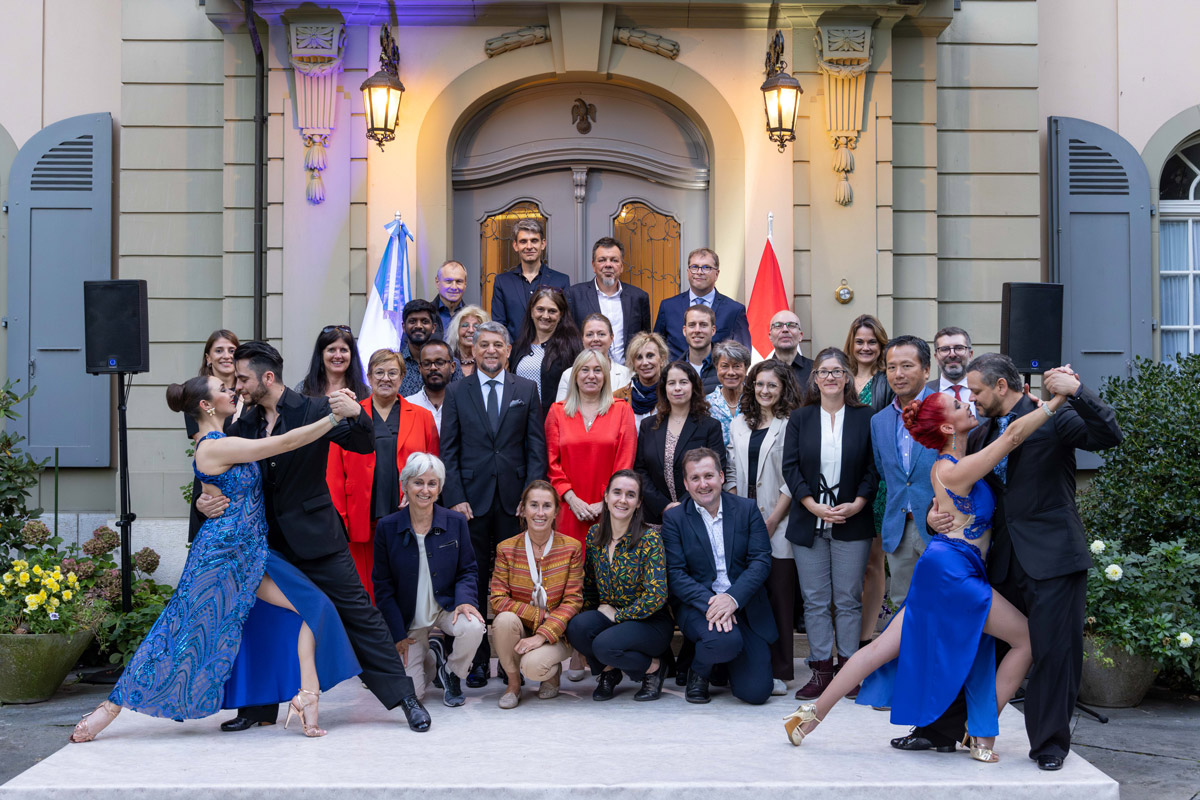 A group of people pose for a photo in front of a house.