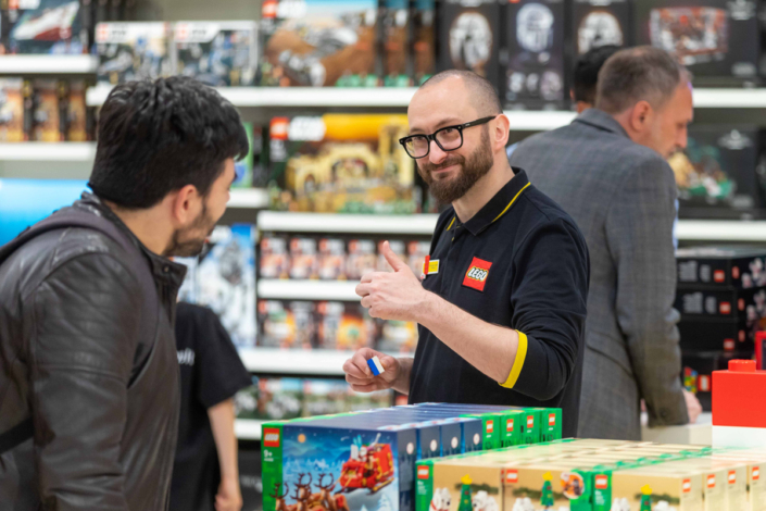 Ein Mann betrachtet Legoboxen in einem Geschäft.