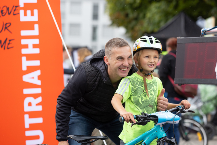 A man and a child stand next to each other at an event.