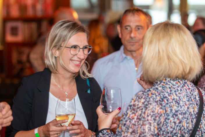 Eine Gruppe von Menschen trinkt Wein auf einer Party.