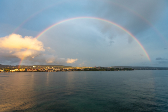 Ein doppelter Regenbogen über einem Gewässer.