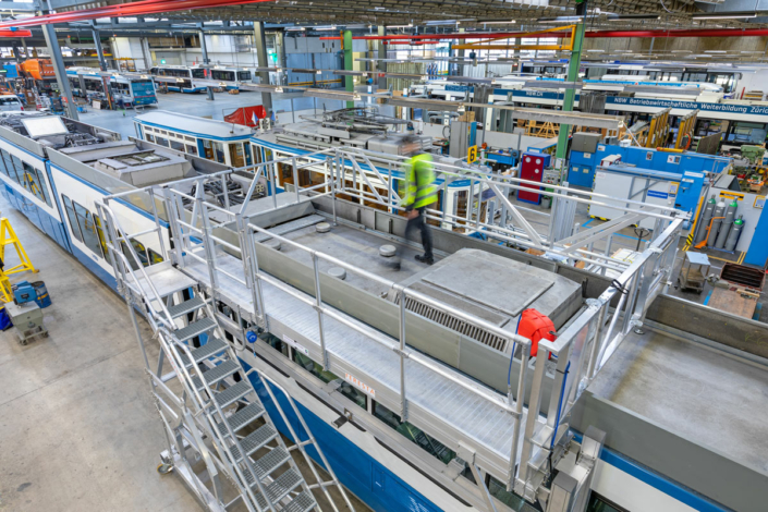 A blue and white train in a factory.