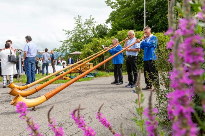 A group of people stand next to a group of wooden horns.