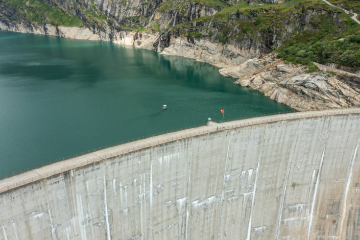 An aerial view of a dam with a boat in the water.