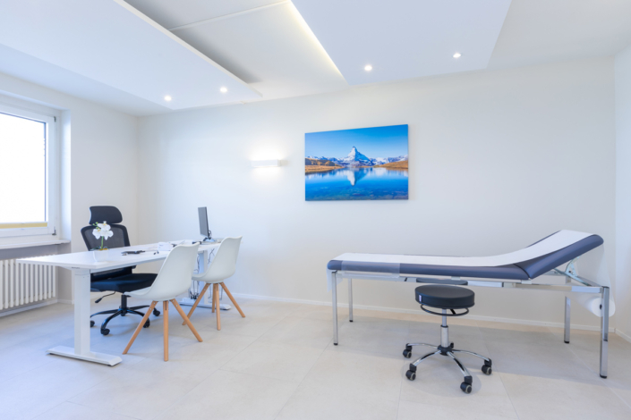 A doctor's office with a white desk and chair.