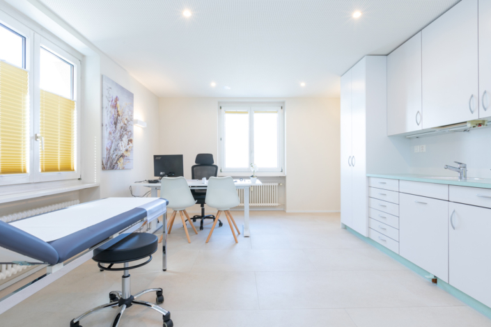 A doctor's surgery with desk and chairs.