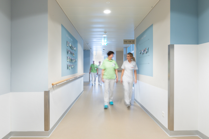 Two nurses walk down a corridor.