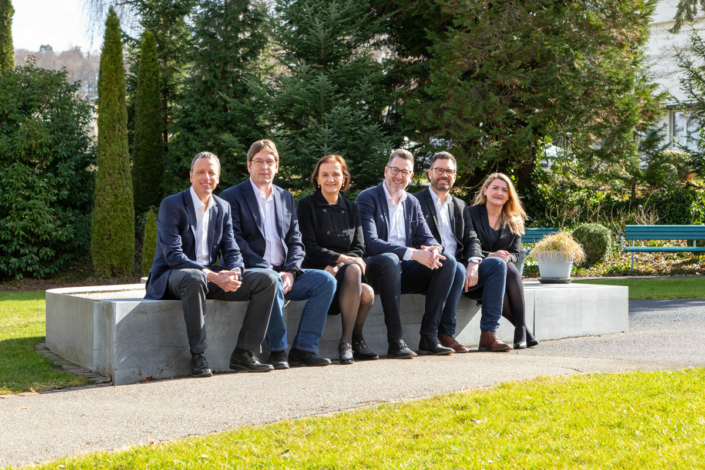 A group of people are sitting on a bench.