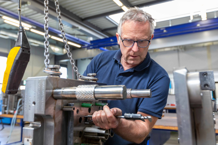 A man is working on a machine in a factory.